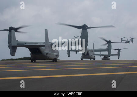 MV-22B avions à rotors basculants Osprey décollage de l'hélicoptère à l'atterrissage au pad dock Shima Ie centre de formation, Okinawa, Japon, 14 août 2019. La création d'un armement de l'avant et l'essence de l'expédition amphibie expeditionary marine démontre l'intégration dans l'ensemble de capacités air-sol marin Task force de combat et de domaines. (U.S. Marine Corps photo de la FPC. Francesca Landis) Banque D'Images