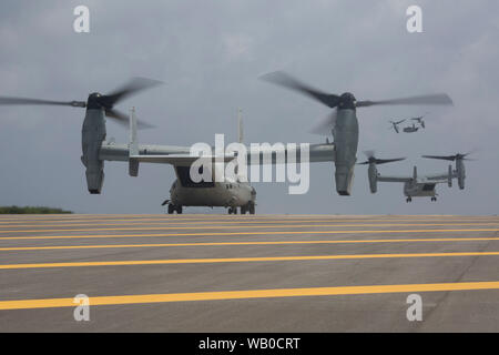 MV-22B avions à rotors basculants Osprey décollage de l'hélicoptère à l'atterrissage au pad dock Shima Ie centre de formation, Okinawa, Japon, 14 août 2019. La création d'un armement de l'avant et l'essence de l'expédition amphibie expeditionary marine démontre l'intégration dans l'ensemble de capacités air-sol marin Task force de combat et de domaines. (U.S. Marine Corps photo de la FPC. Francesca Landis) Banque D'Images