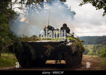 Déploiement de soldats ukrainiens dans un BMP-1 suivi amphibie de combat d'infanterie, pour se défendre contre les forces d'opposition (OPFOR) au cours d'une bataille simulée dans "la boîte" au cours du dernier exercice de force contre force résoudre combiné à la XII préparation interarmées multinationale Centre à Hohenfels, Allemagne Le 19 août, 2019. Résoudre combinées de l'armée américaine est une publication semestrielle de l'Europe et 7e armée dirigée par l'exercice de la commande de formation destiné à évaluer et à certifier l'état de préparation et l'interopérabilité des forces nous mobiliser pour l'Europe en faveur de la résolution de l'Atlantique. (U.S. Photo de l'armée par le Sgt. Thomas Mort) Banque D'Images