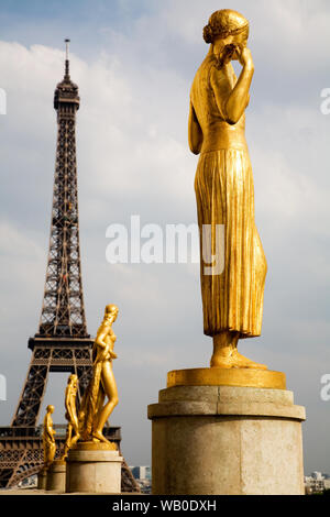La France. Paris. Des statues en bronze doré debout dans la place centrale du Palais de Chaillot, avec la Tour Eiffel en arrière-plan. Banque D'Images