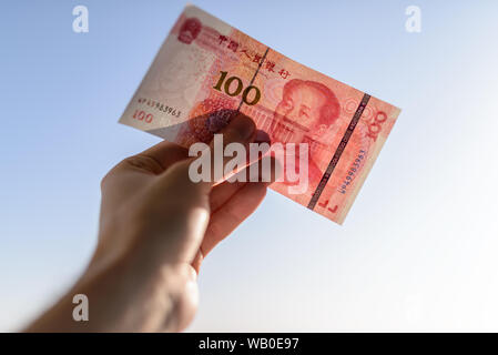 100 yuan en main. Focus sélectif et profondeur de champ. Banque D'Images