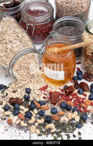 Pot de miel avec des baies, noix et graines d'avoine Banque D'Images
