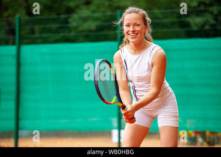 Heureux tennis player holding la raquette en position d'attente. Banque D'Images