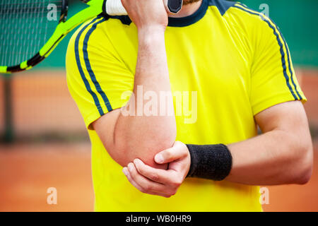 Joueur de tennis masculin tenant son coude blessé. Le coude de tennis concept. Banque D'Images