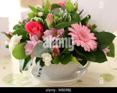 Bouquet de fleurs roses dans une grande tasse Banque D'Images