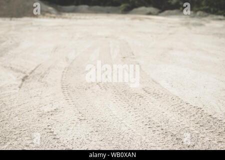 La texture des traces de pneus de tracteur sur le terrain Banque D'Images