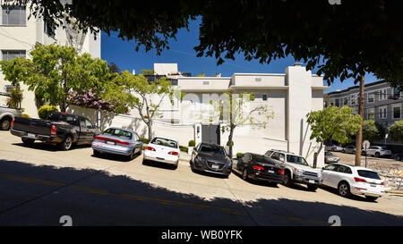SAN FRANCISCO, CALIFORNIE / USA : des voitures garées dans une rue en pente de San Francisco, scène encadrée entre les zones ombragées. Banque D'Images