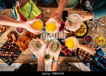 Groupe d'amis tous âges, des enfants aux générations futures s'amuser adultes togeter avec nourriture et boissons - vue aérienne Vue de dessus de table et people toasting à Banque D'Images