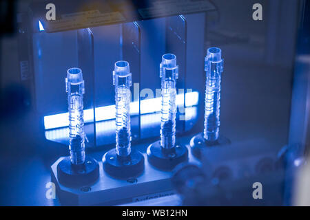 Schwerin, Allemagne. Août 22, 2019. La clarté des détenteurs de cartouche pour des seringues à insuline produite dans une machine de moulage par injection est testé avec une lumière colorée dans l'un des halls de production de la nouvelle usine de la société de technologie médicale Ypsomed. L'entreprise fabrique des ensembles de perfusion pour les diabétiques et les dispositifs d'injection pour l'administration de médicament liquide. Autour de 81 millions d'euros ont été investis dans la nouvelle usine de production. Credit : Jens Büttner/dpa-Zentralbild/ZB/dpa/Alamy Live News Banque D'Images