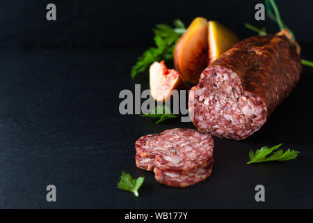 Concept alimentaire saucisse séchée séchées sur black slate board with copy space Banque D'Images