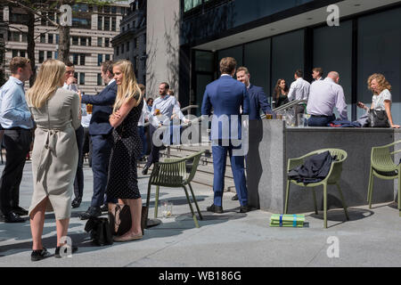 Les travailleurs de la ville de midi prendre un verre au soleil d'été à l'extérieur du bâtiment de Swiss Re (aka le Gherkin), dans la ville de Londres, le quartier financier de la capitale (aka le Square Mile), le 22 août 2019, à Londres, en Angleterre. Banque D'Images