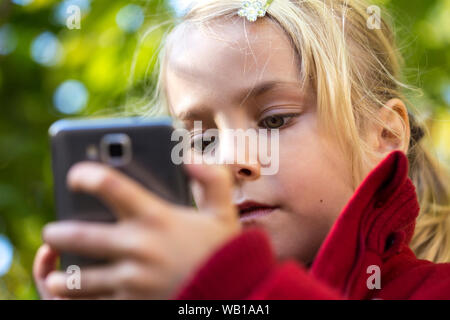 Portrait of little girl using smartphone Banque D'Images