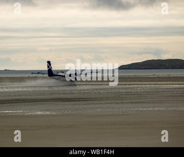 L'aéroport de Barra, Hébrides extérieures, en Écosse. Loganair les Twin Otter à l'atterrissage et au décollage à l'aéroport. Banque D'Images