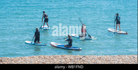 Lyme Regis, dans le Dorset, UK. 23 août 2019. Météo France : Paddle boarders profiter de la mer de refroidissement à la ville balnéaire de Lyme Regis. Ce week-end est définie pour être la plus chaude d'août vacances de banque sur dossier. Credit : Celia McMahon/Alamy Live News. Banque D'Images