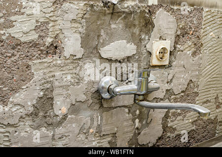 Ancien robinet de cuisine sur un mur pendant les travaux de reconstruction Banque D'Images