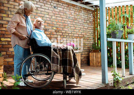 Focus sélectif de cheerful senior femme debout près de personnes handicapées en fauteuil roulant, mari Banque D'Images