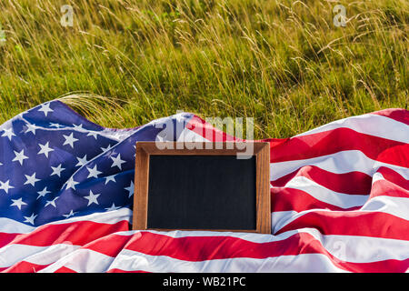 Blank chalkboard sur drapeau américain avec des stars and stripes on Green grass Banque D'Images