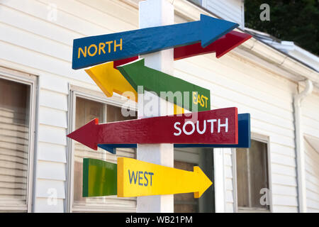 Signe avec Nord, Sud, Est et Ouest flèches pointant dans des directions différentes. Banque D'Images