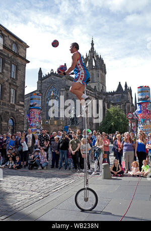 Royal Mile, Edinburgh, Ecosse, Royaume-Uni. 23 août 2019. Basket-ball Jones jongle balles et une torche de feu sur la rue principale, avec la cathédrale St Giles dans l'arrière-plan. Banque D'Images