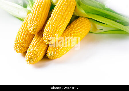 Maïs bonduel jaune juteux frais avec des feuilles vertes se trouve sur la table en bois Banque D'Images