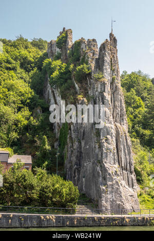 Dinant, Belgique - 26 juin 2019 : Le rocher Bayard le long de la Meuse, entourée de feuillage vert sous ciel bleu. Banque D'Images