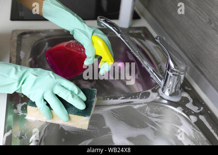 Femmes mousse savonneuse évier pour lave-vaisselle. Conque de cuisine avec la mousse. Lavabo et mitigeur avec des résidus de mousse. Un nettoyage cuisine métal conque. Des Banque D'Images