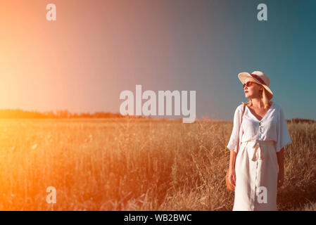 Jeune femme en mode rétro debout dans la lumière du soleil Banque D'Images