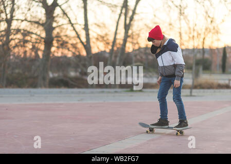 Skateboarder Kid faisant un tour de planche à roulettes. Banque D'Images