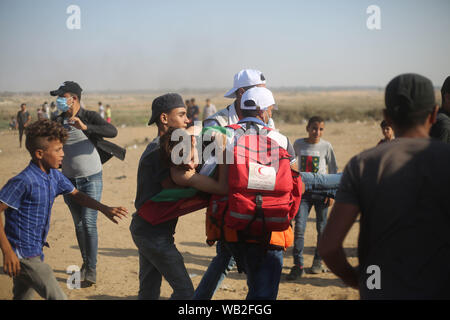 Gaza, la Palestine. Août 23, 2019. Les médecins palestiniens portent un garçon blessé lors d'affrontements avec les troupes israéliennes sur la frontière Gaza-Israel, à l'est du sud de la bande de Gaza ville de Khan Younis, le 23 août 2019. Au moins 122 Palestiniens, y compris trois ambulanciers, ont été blessés vendredi lors d'affrontements avec des soldats israéliens à l'est de Gaza. Credit : Khaled Omar/crédit : Xinhua Xinhua/Alamy Live News Banque D'Images