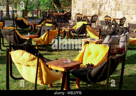 Sacs et fauteuils tables sur l'herbe dans un café. L'intérieur de l'été cafe. Meuble d'été dans un restaurant Banque D'Images