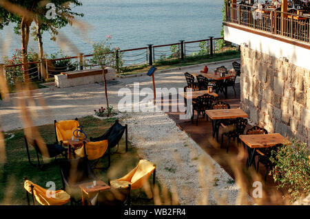 Sacs et fauteuils tables sur l'herbe dans un café. La mer en arrière-plan. L'intérieur de l'été cafe. Meuble d'été dans un restaurant Banque D'Images