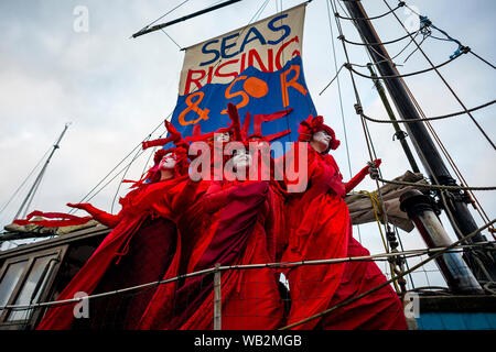 Rivière Fal, Falmouth, Cornwall, UK. La troupe de réserve de performance de la Brigade rebelle rouge descendre la rivière Fal la prise de conscience de la crise climatique. Banque D'Images