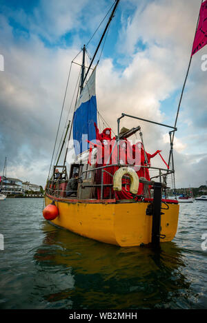 Rivière Fal, Falmouth, Cornwall, UK. La troupe de réserve de performance de la Brigade rebelle rouge descendre la rivière Fal la prise de conscience de la crise climatique. Banque D'Images