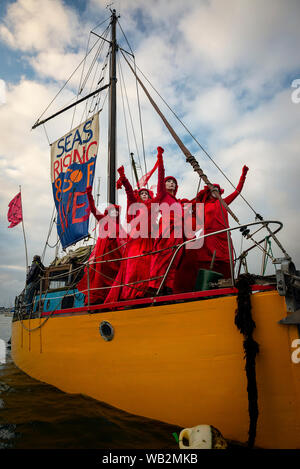 Rivière Fal, Falmouth, Cornwall, UK. La troupe de réserve de performance de la Brigade rebelle rouge descendre la rivière Fal la prise de conscience de la crise climatique. Banque D'Images