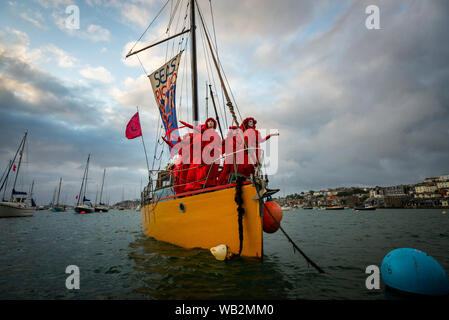 Rivière Fal, Falmouth, Cornwall, UK. La troupe de réserve de performance de la Brigade rebelle rouge descendre la rivière Fal la prise de conscience de la crise climatique. Banque D'Images