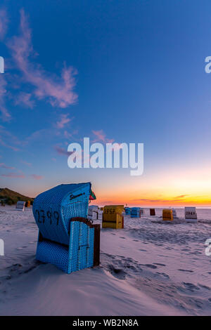 Chaises de plage après le coucher du soleil sur la plage de Juist, îles de la Frise orientale, en Allemagne. Banque D'Images