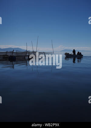 Lever du soleil dans un élevage de truite flottante sur le lac Titicaca. Le Uru ou Uros sont un peuple autochtone du Pérou et de la Bolivie, qui vivent sur une centaine d'îles flottantes, faites de Totora Reed, dans le lac Titicaca près de Puno. Banque D'Images