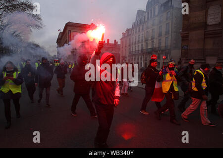 Gilet jaune portant des manifestants envoyer la fumée jaune dans l'air pendant une protestation mars en face de l'hôtel de ville à Paris le 5 janvier 2019 à Pari Banque D'Images