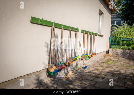 Un grand nombre de petites manches couleur accrocher sur le mur extérieur d'un jardin d'enfants Banque D'Images