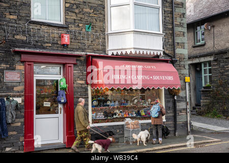 Couple promènent leurs chiens dans le village anglais de Coniston dans le parc national de Lake District sur une journée l'hiver,Cumbria, Angleterre Banque D'Images