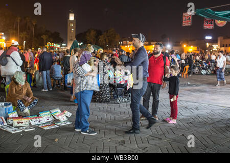 Marrakech, Maroc - 12 mars 2019 : les touristes de prendre des photos avec un singe sur une chaîne à Marrakech, Maroc. Banque D'Images