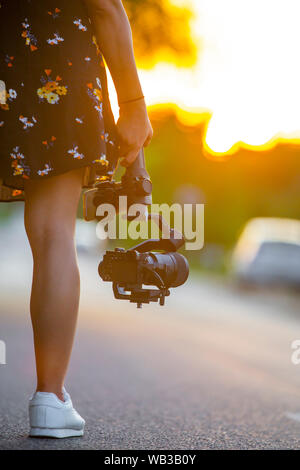 Une jeune fille tenant une caméra montée sur une tourelle gyrostabilisée. Banque D'Images