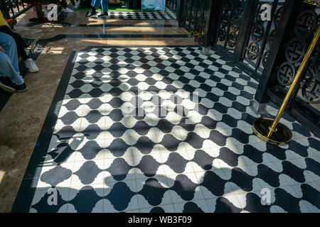 Sol en damier noir et blanc carreaux grunge en surface dans un endroit public avec des gens et les jambes Banque D'Images