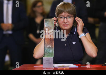 Gdansk, Pologne 23, août 2019 Natalia Kaplan, une cousine soeur de prisonnier politique ukrainien, Oleg Sentsov réalisateur recevant maire de Gdansk Prix statue d'Aleksandra Dulkiewicz et Agnieszka Holland mains dans nom d'Oleg Sentsov est visible pendant le débat sur la liberté de l'artiste à Gdansk, Pologne le 23 août 2019 . 11e édition du Festival des Arts de la solidarité a invité des artistes qui sont motivés par leur courage. Cette yearÕs canapé a un héros symbolique : Oleg Sentsov, un réalisateur Ukrainien accusé par les services RussiaÕs du terrorisme et condamné à 20 ans dans un camp de travail sibérien. Banque D'Images