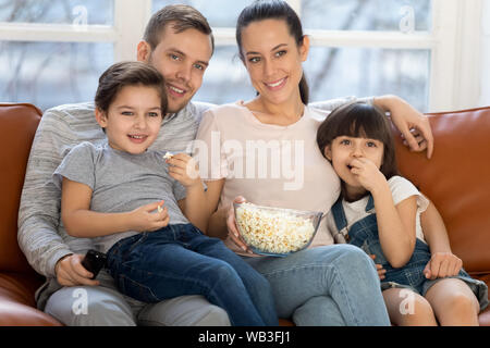 Famille heureuse maman papa et les enfants à regarder la télévision ensemble Banque D'Images