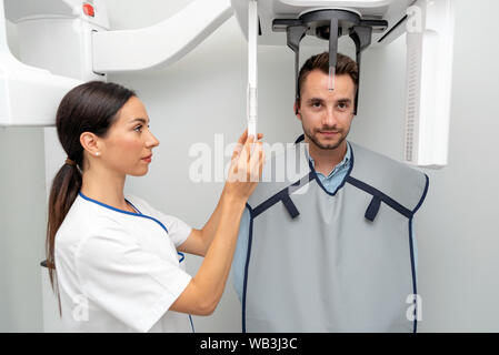 Bel homme patient debout dans x-ray machine. À la radiographie panoramique dentaire professionnel. Banque D'Images