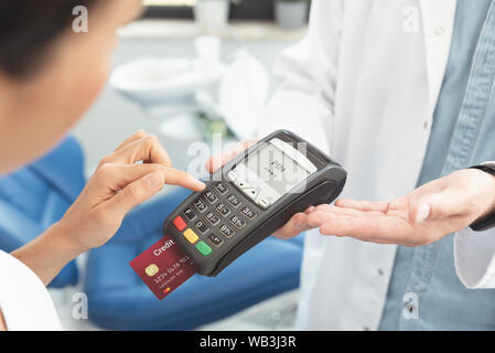 Médecin est maintenant dans les mains de terminaux de paiement. Payer pour les soins de santé. Banque D'Images