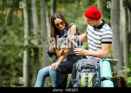 Hiker homme verse du thé ou du café à la Tasse thermos de forêt en été Banque D'Images