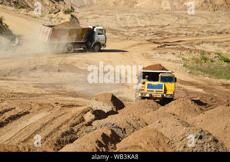 Big Yellow de camions à benne travaillant dans la mine à ciel ouvert. Transport de sable et de minéraux. Carrière minière pour la production de pierre concassée, sable et gravier pour Banque D'Images