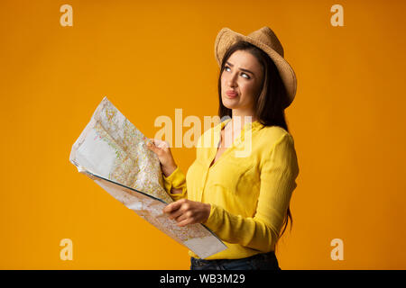 Ennuyer Traveler Girl Holding Site Planning prochain voyage, Studio Shot Banque D'Images